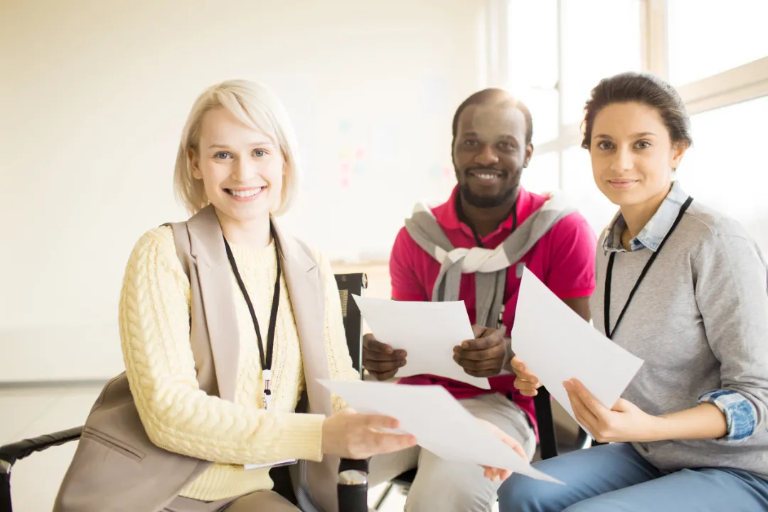 Multiethnic group of people sitting on chairs on seminar